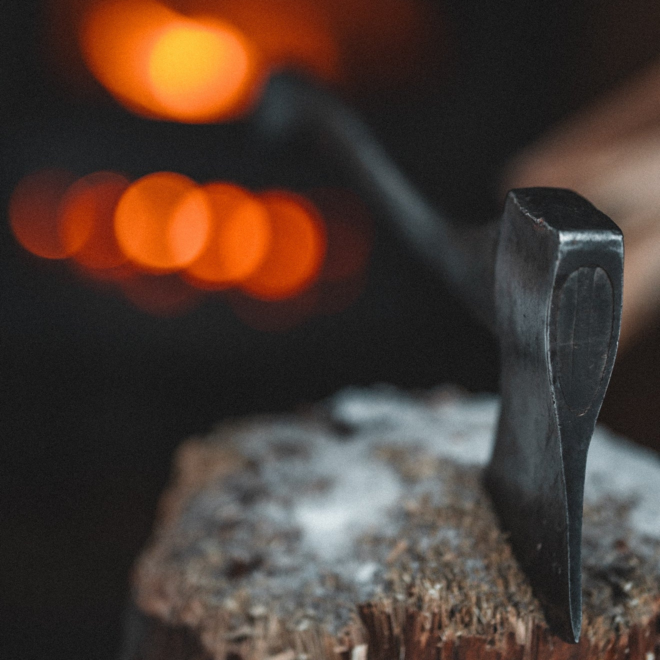 Blacksmith's hammer on an anvil with a blurred background of flames