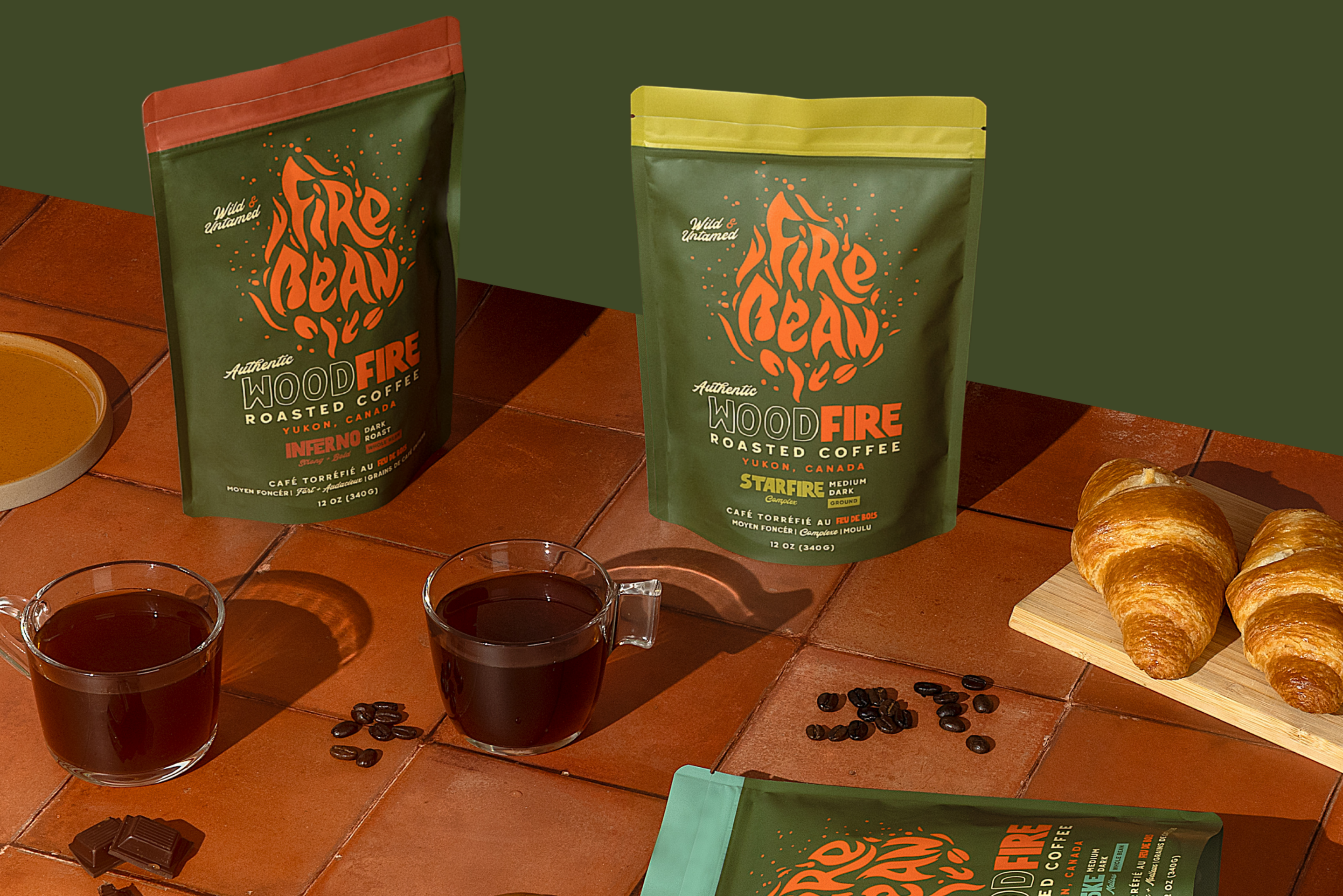 Two packages of 'The Bean That Got Away' coffee on a wooden table with croissants and coffee cups.